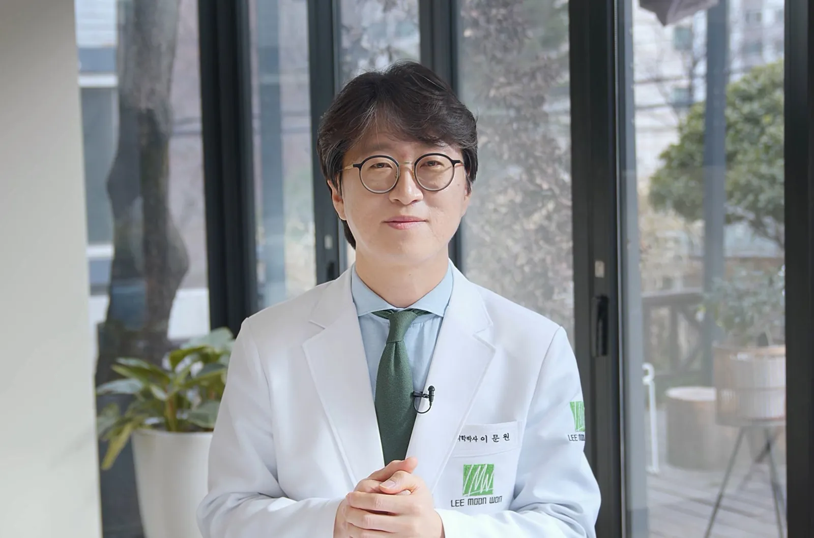 흰 가운을 입은 이문원 대표원장, 한의원 창가